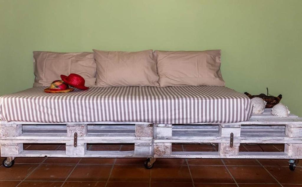 迈萨纳Ξενώνας Αρσινόη- ΜΕΘΑΝΑ ΜΕΓΑΛΟΧΩΡΙ的一张床上,坐在房间里