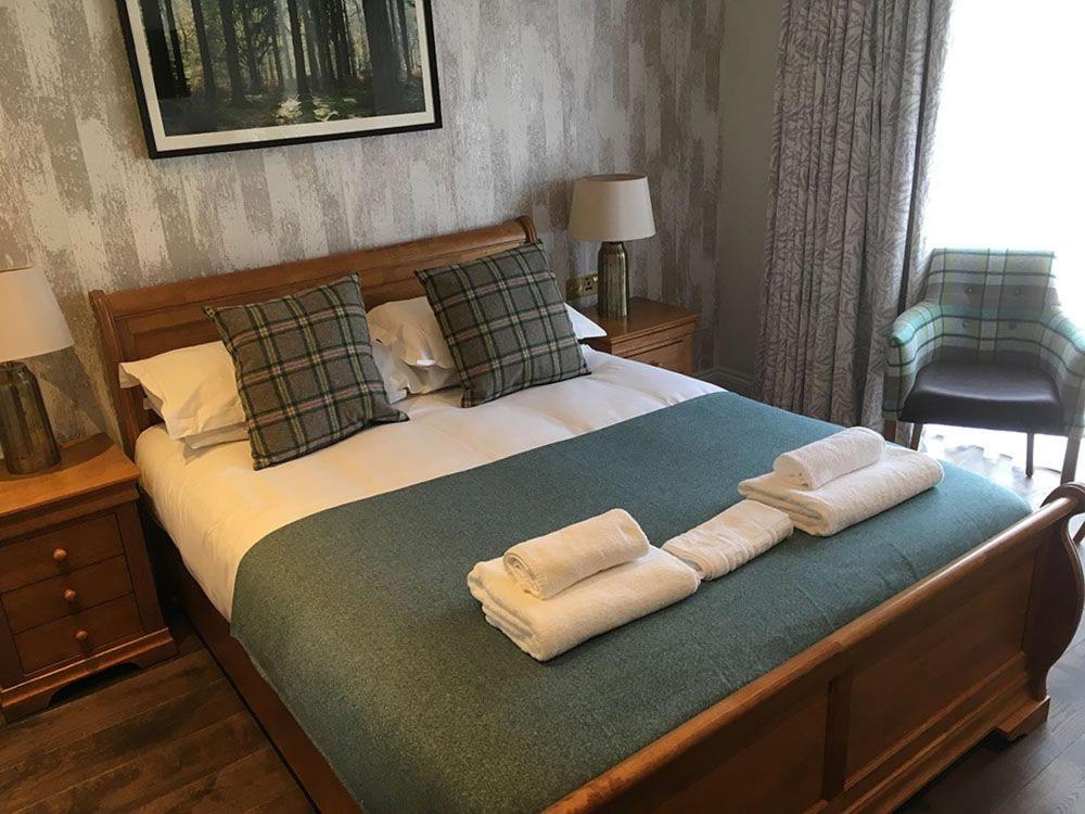 巴斯Charlcombe Inn的一间卧室配有一张床,上面有两条毛巾