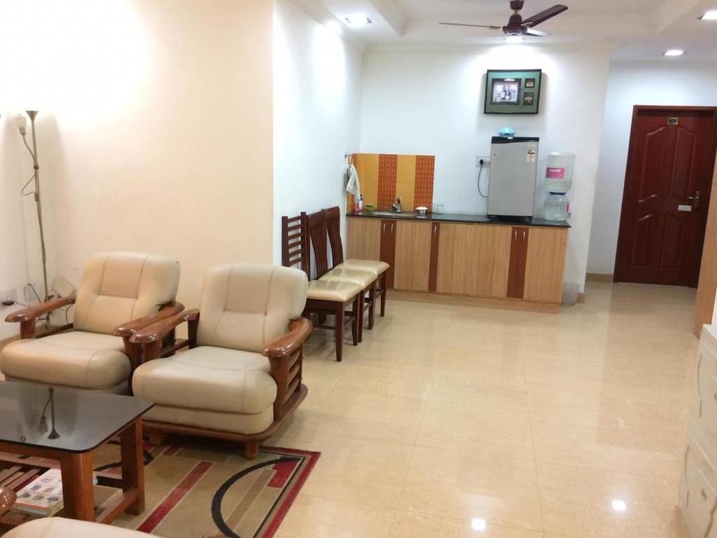 钦奈Swarna Sudarshan Service Apartment @ Adyar chennai的一间诊所的候诊室,配有椅子和冰箱