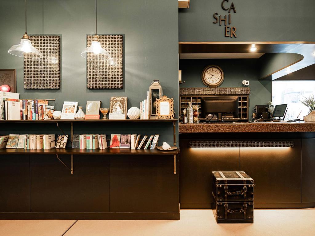 延冈市诺贝卡地区酒店 的一间咖啡店,里面装有书架和时钟