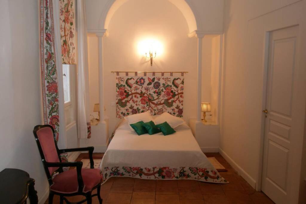图卢兹Logis de Sainte-Scarbes的一间卧室配有一张带绿色枕头的床。