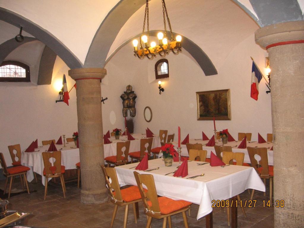 EmskirchenAlte Poststation Goldener Hirsch的用餐室配有桌椅和红色餐巾