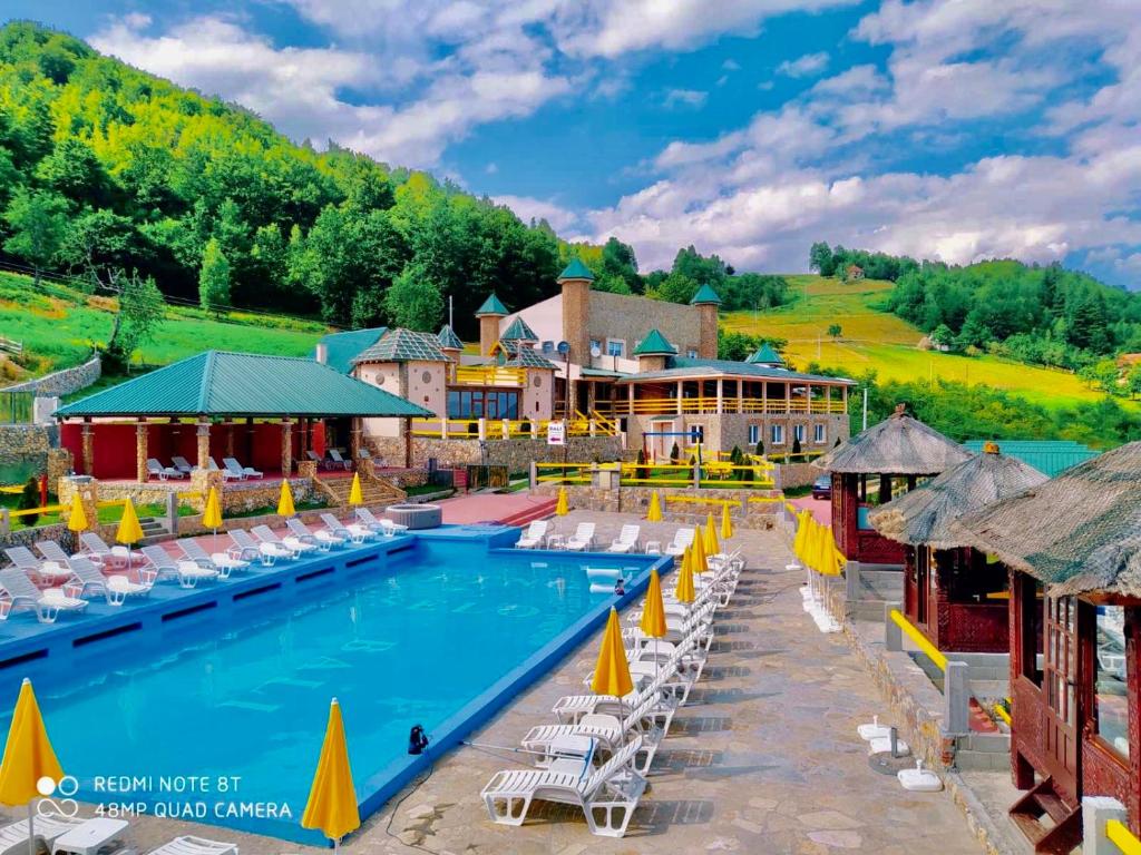 比耶洛波列Bali Mountain resort Montenegro的度假村的游泳池,配有椅子和遮阳伞