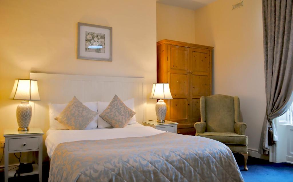 都柏林巴格特宫殿联排别墅酒店的配有一张床和一把椅子的酒店客房