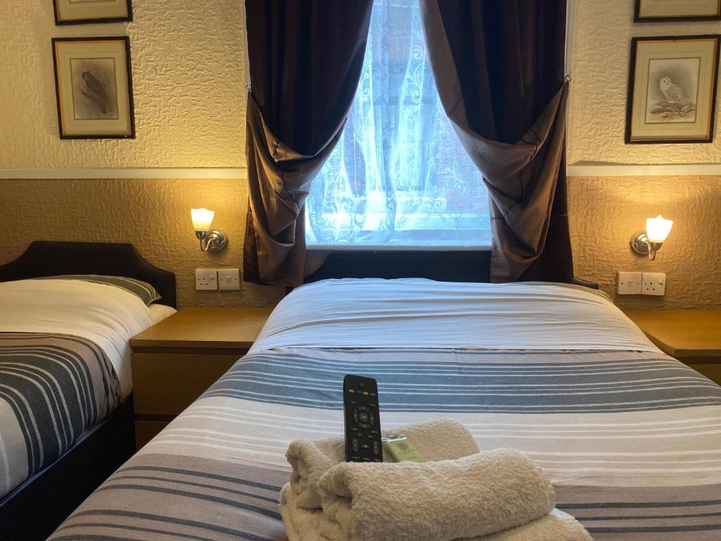 布莱克浦Grange House Hotel的一间卧室配有一张带遥控器的床