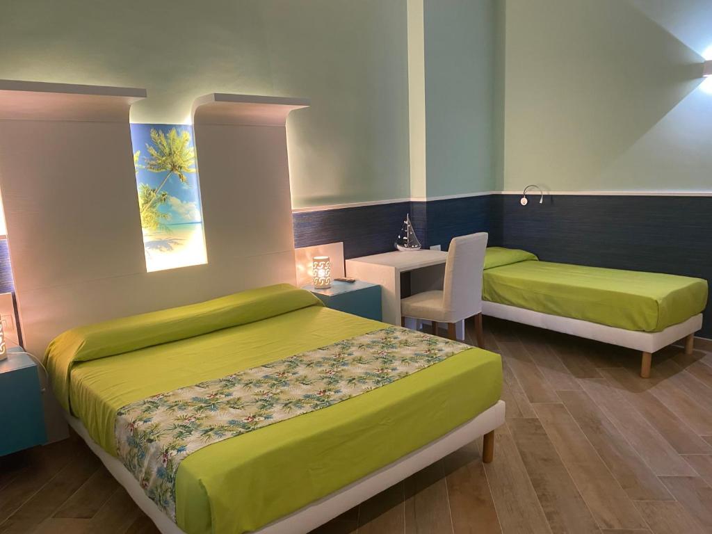 焦维纳佐Porto di mare b&b的一间卧室配有两张床、一张桌子和一张书桌