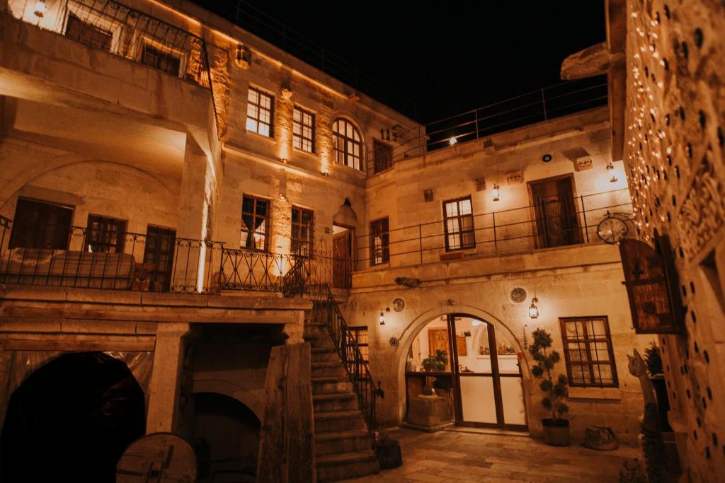 内夫谢希尔Cappadocia Eagle Cave Inn的一座古老的石头建筑,设有楼梯和阳台