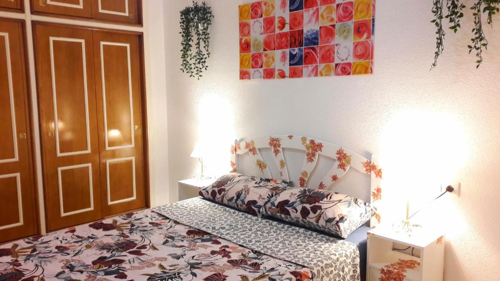 托雷维耶哈NICE 2-BEDROOMS的一间卧室配有一张带鲜花床罩的床