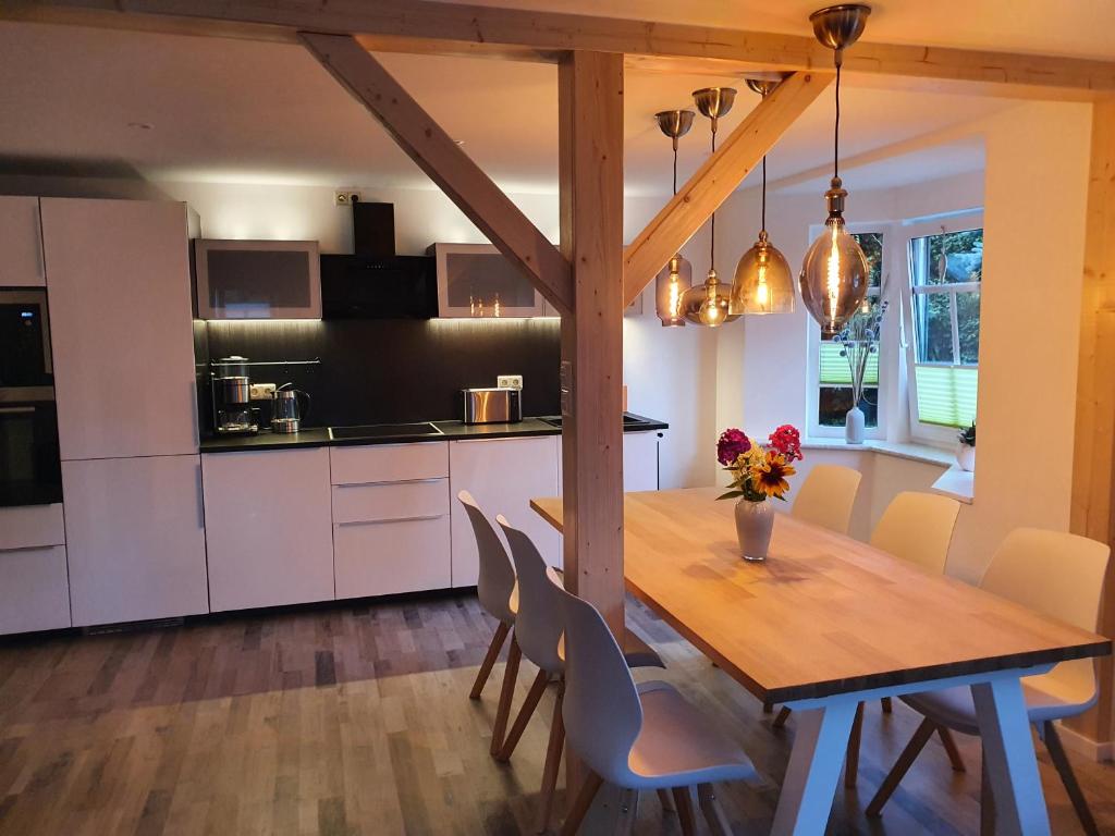 克林根塔尔Gute Laune Hof Klingenthal的厨房以及带木桌和椅子的用餐室。