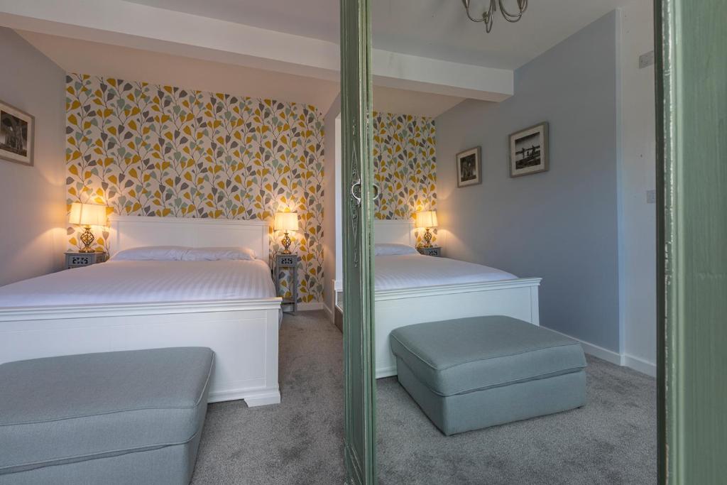 荷尼湾The Sleep-Inn Hare B&B的一间卧室配有两张床和镜子
