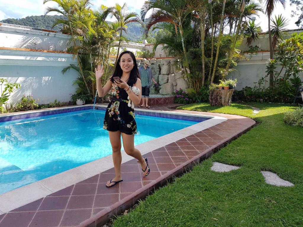 帕纳哈切尔佩拉玛雅酒店的一位女士站在游泳池旁边