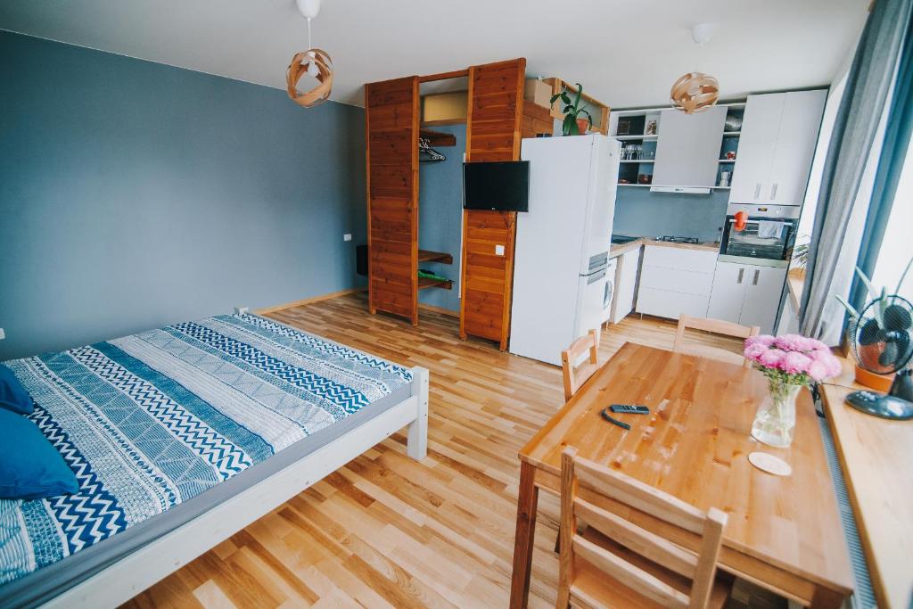 瓦尔米耶拉City center Appartment的一间卧室配有一张床铺和一张桌子,还设有一间厨房