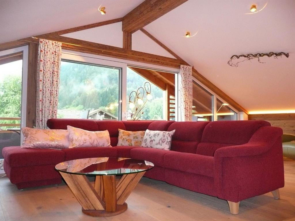 普夫龙滕Alpenstern Ferienwohnung的客厅配有红色的沙发和桌子