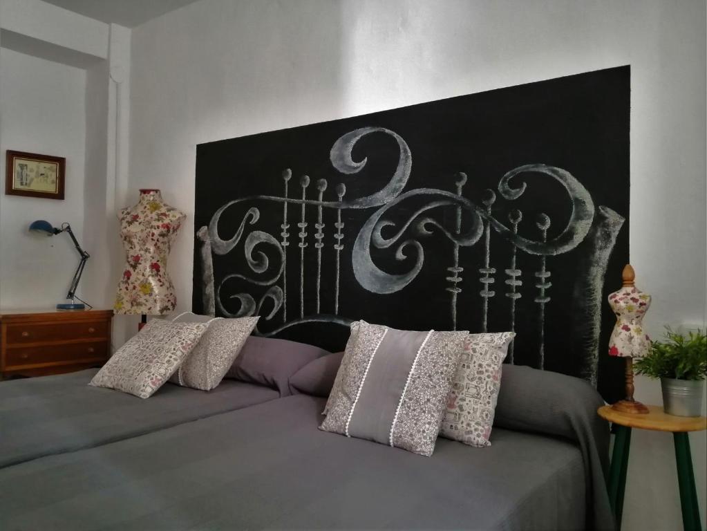 普里埃格·德·科尔多巴Casa de La Costurera的一张带黑色床头板和一些枕头的床