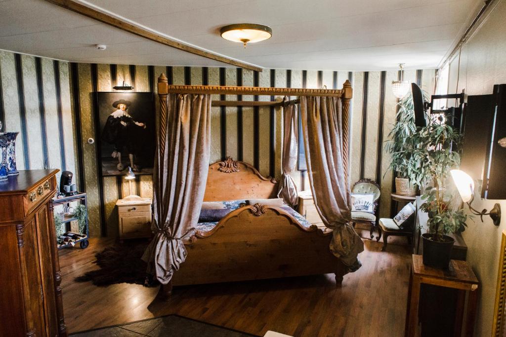 Warfstermolen杜斯耶住宿加早餐旅馆的一间卧室配有带窗帘的天蓬床