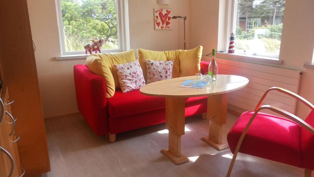 兰图姆Mini Beach House I Sylt/Rantum的客厅配有红色的沙发和桌子