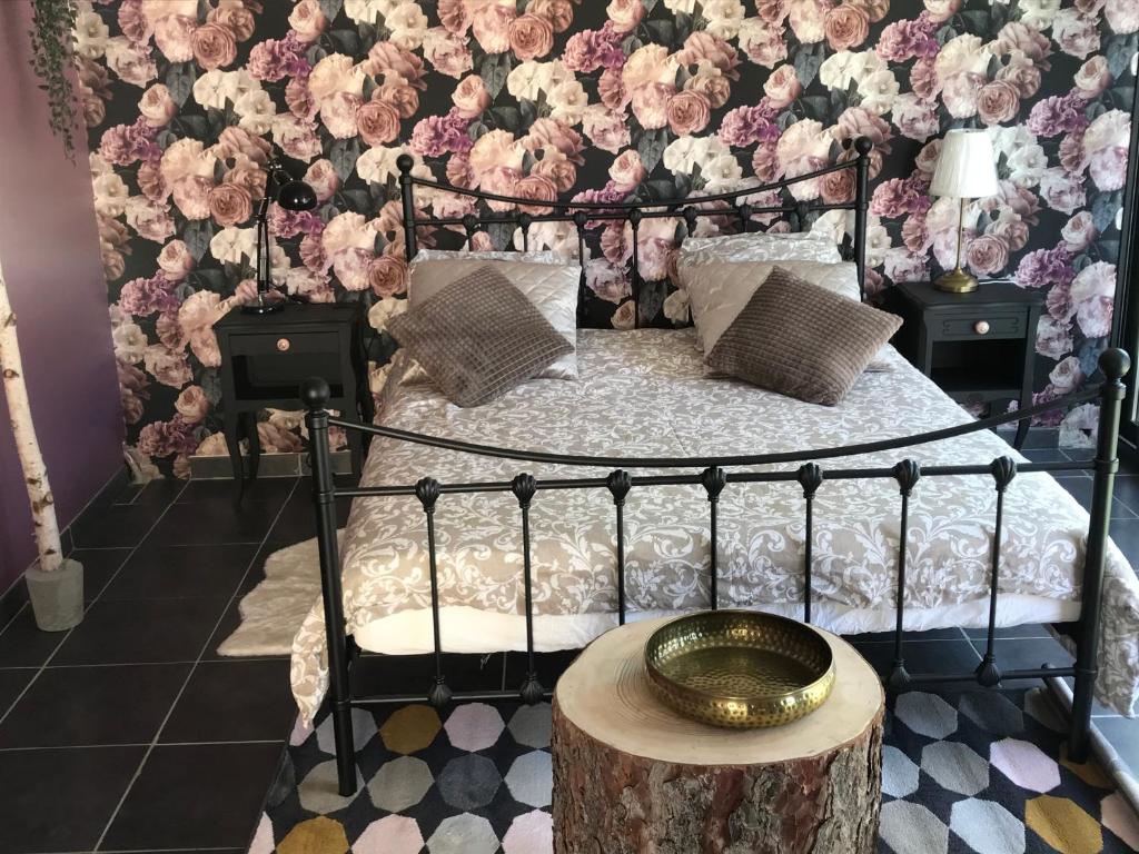 芒德La Roséa的卧室配有一张墙上鲜花的床