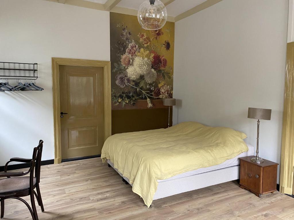 ElstBed & Breakfast Bloemen Vertellen的卧室配有一张床,墙上挂有绘画作品