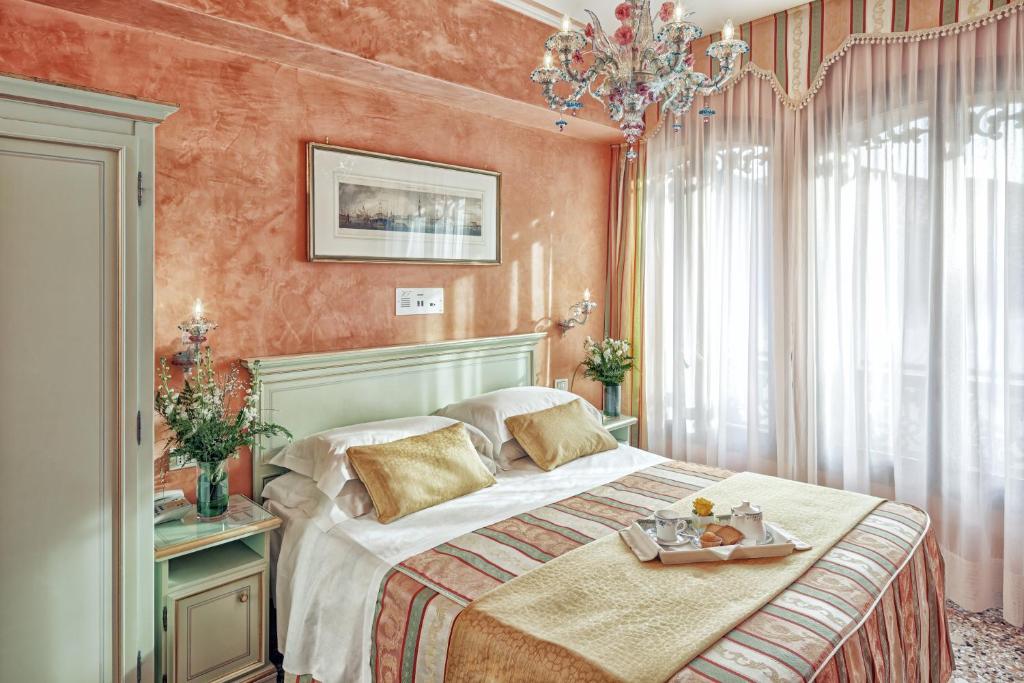 威尼斯菲兰其酒店的一间卧室配有一张床,上面放着一个食物托盘