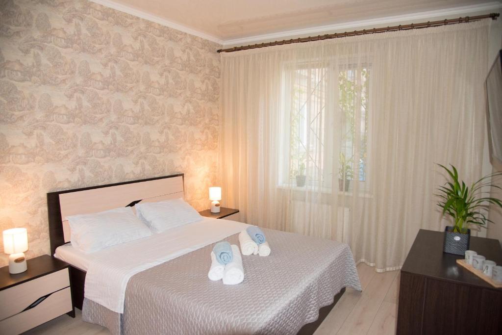 敖德萨Center of Odessa. Comfortable 2 rooms apartment的一间卧室配有一张床,并备有2个拖鞋