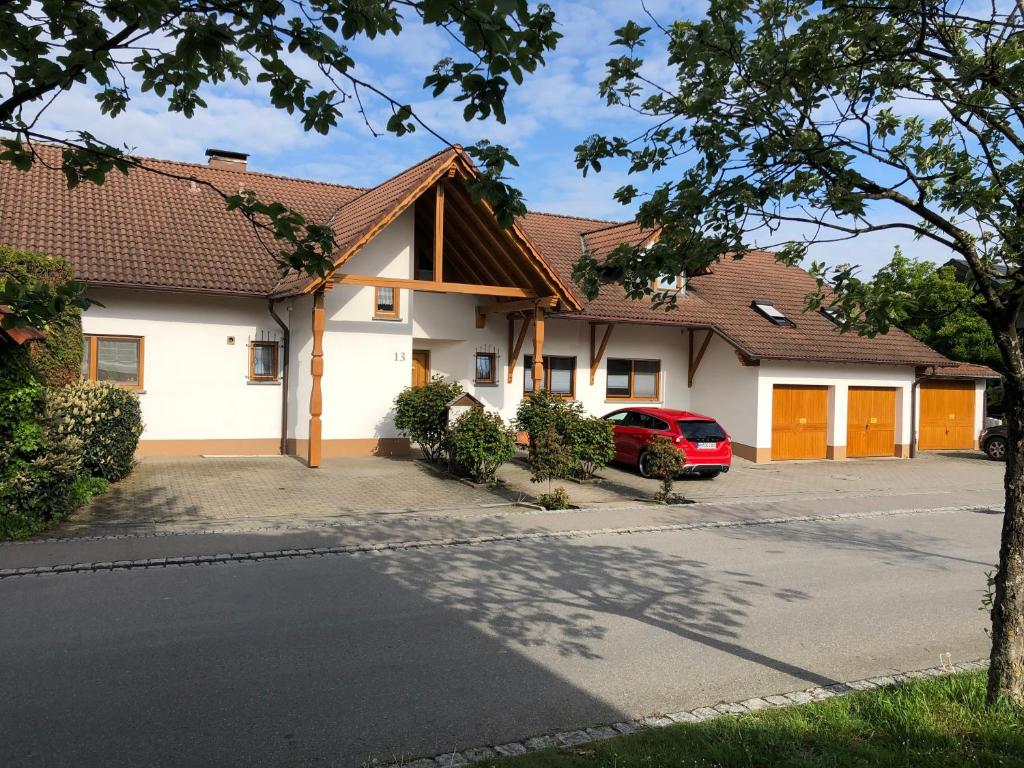 梅肯博伊伦Landhaus Monika的前面有一辆红色汽车的房屋