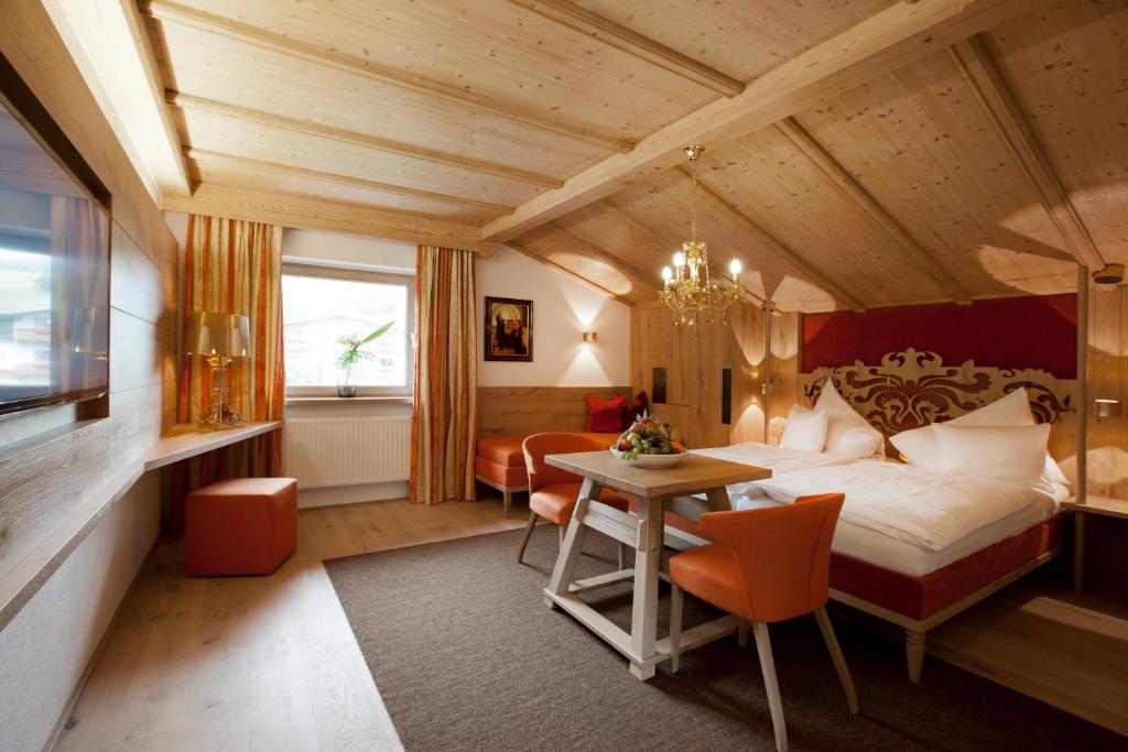 蒂罗尔-基希贝格Minglers Sportalm - Das Gourmet- und Genießerhotel的卧室配有一张床和一张桌子