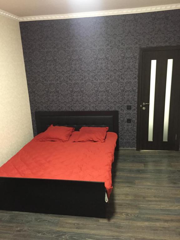 克洛佩夫尼茨基Отель Переулок средний 16的一间卧室配有红色的床和红色毯子