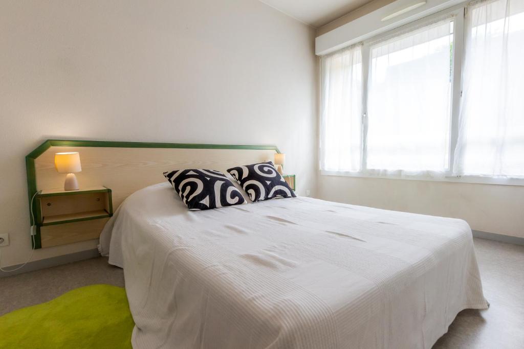 ÉpronSphinx Résidences - Les Germes de Blé的卧室配有一张带枕头的大型白色床。