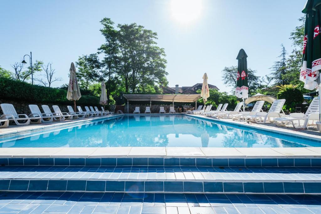 大格拉迪什泰ATOS Srebrno jezero - Villa and Restaurant的一个带椅子的大型游泳池