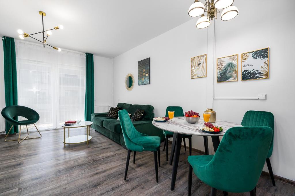 波兹南Sleepway Apartments- Garbary 100-46的客厅配有桌子和绿色椅子