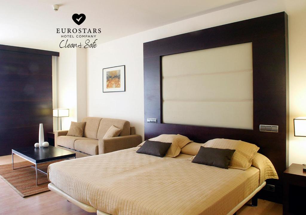 波苏埃洛-德阿拉尔孔欧洲之星马德里酒店的一间卧室配有一张大床和一张沙发