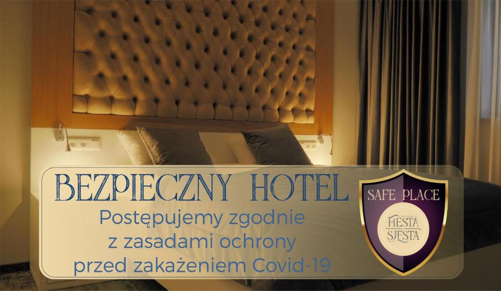 新苏尔Hotel Sjesta的一张在房间带一张床的酒店标志