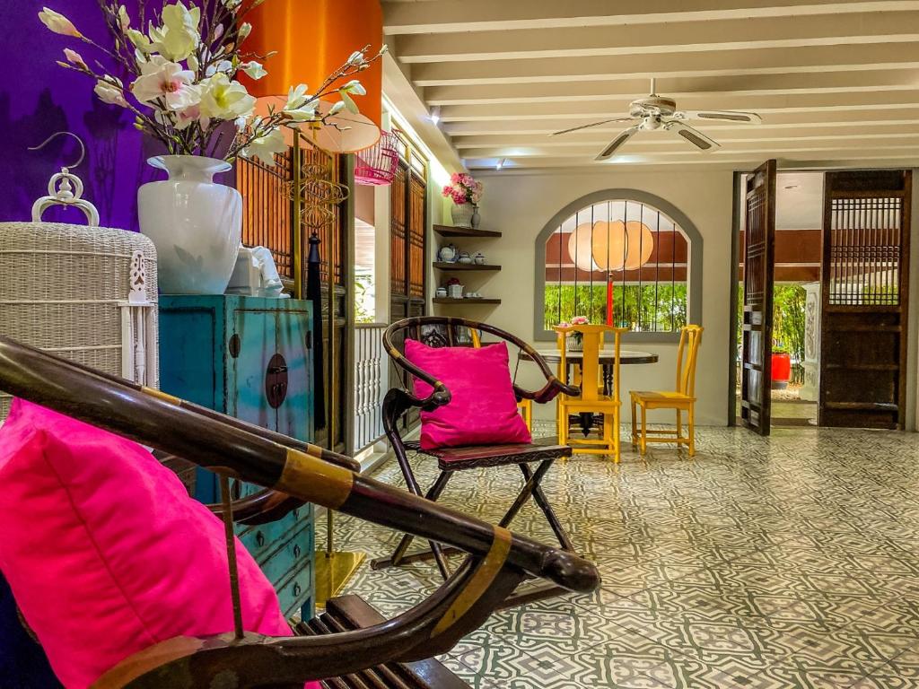 普吉镇Sino House Phuket Hotel - SHA Plus的客厅配有粉红色的椅子和桌子
