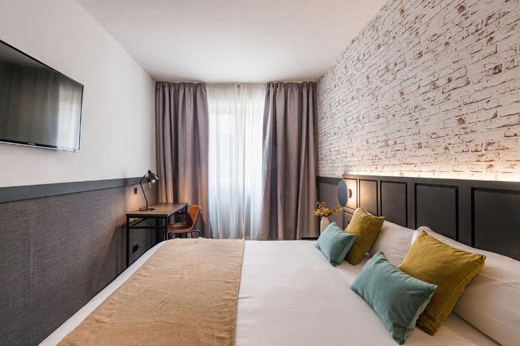 毕尔巴鄂BYPILLOW San Mamés的酒店客房,设有床铺和砖墙