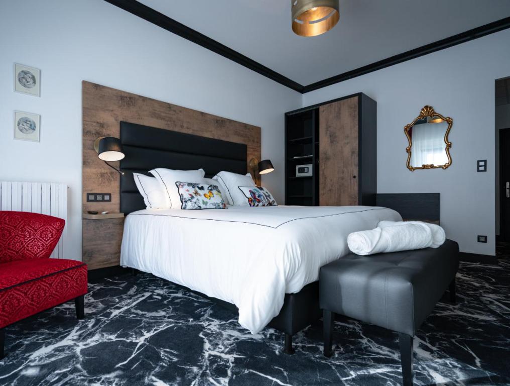 SauveterreHôtel du Barry Resort & Spa的一间卧室配有一张大床和一张红色椅子