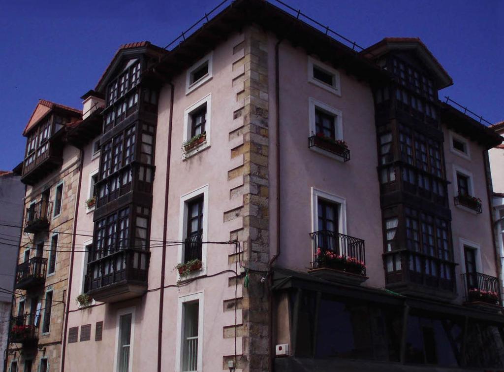 雷诺萨Apartamentos Ebro Reinosa的一座高大的建筑,旁边设有阳台