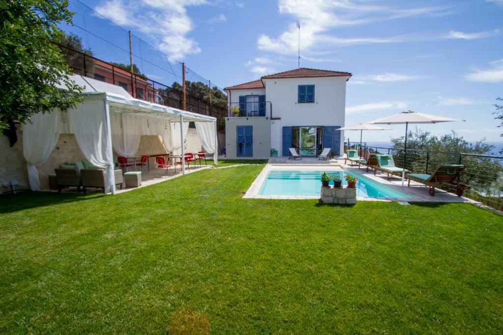 因佩里亚Il Sole di Poggi的一个带游泳池和房子的后院