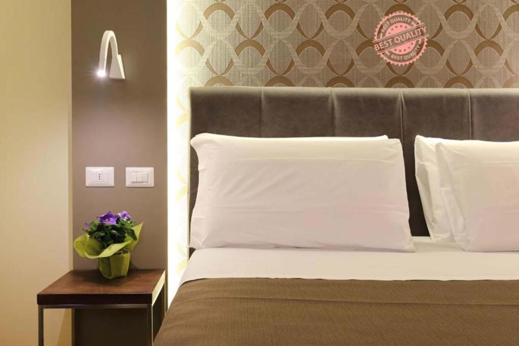 佛罗伦萨萨尔塔莱利旅馆的一间卧室配有一张带床头板的床和一张带鲜花的桌子