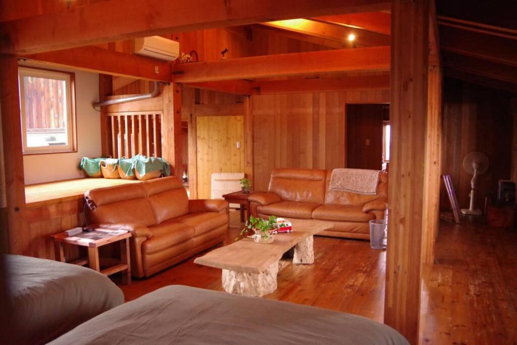 廿日市Miyajima Breeze的客厅配有皮革家具和沙发
