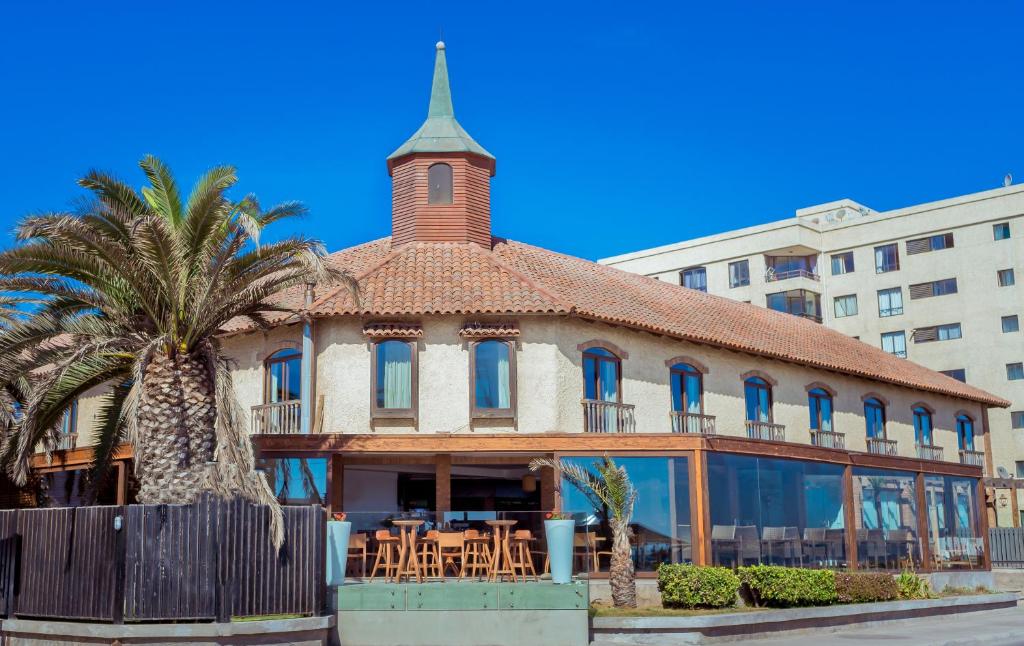 拉塞雷纳坎帕纳里奥德尔马酒店的一座带塔楼和棕榈树的古老建筑