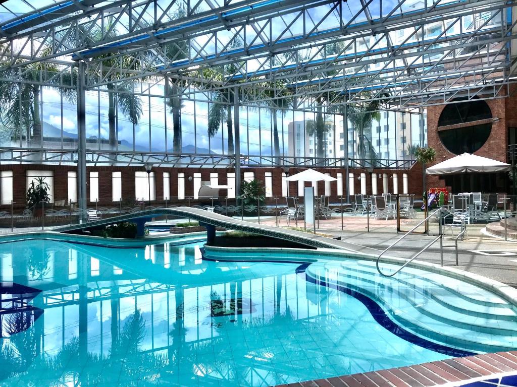 伊瓦格莫拉莱斯国际酒店及会议中心的大楼内一个蓝色的大型游泳池