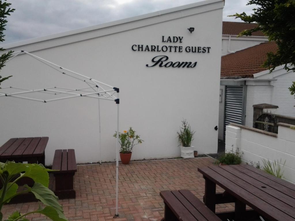 DowlaisLady Charlotte Guest rooms triple rooms的白色车库,设有长椅和阅读女按摩师客房的标志
