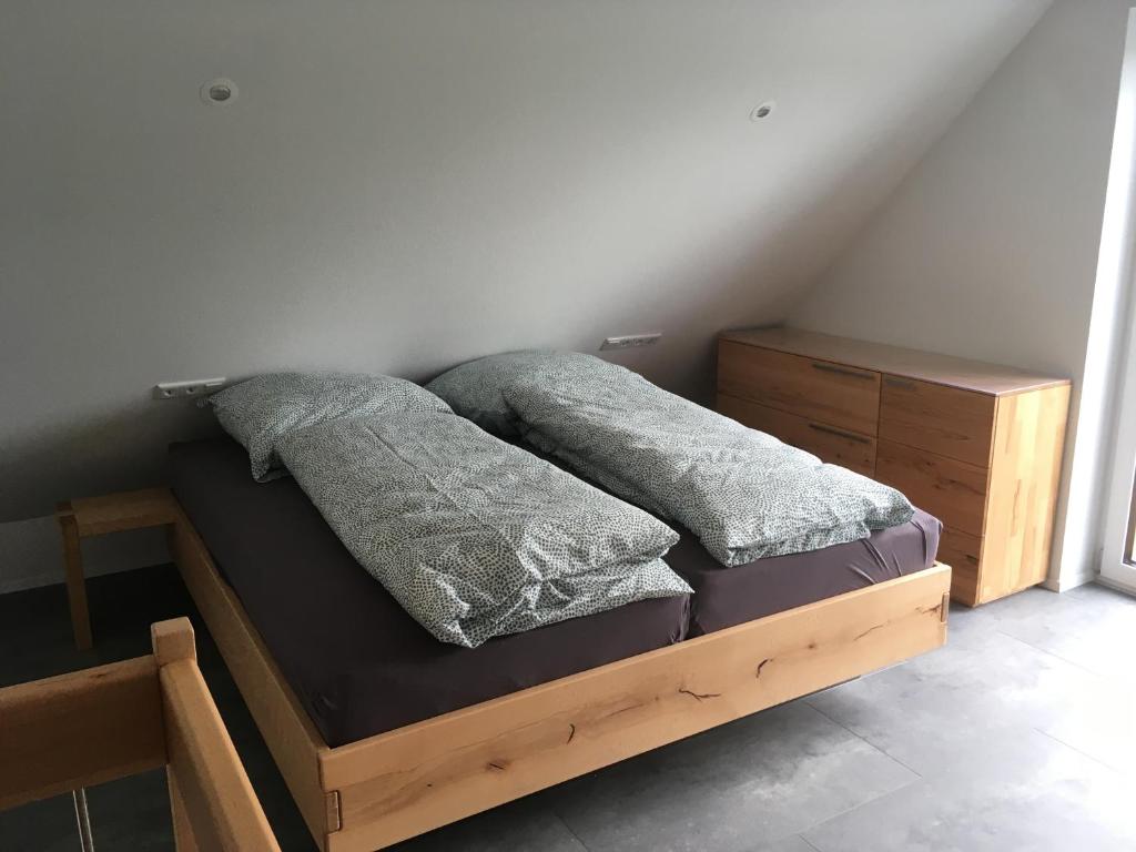 泰克山下基尔夏伊姆Zeitfrei-Apartments的一张木制床,上面有两个枕头