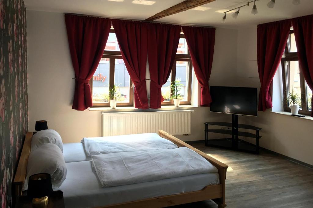 克滕Restaurant & Pension Stadtscheune的一间卧室设有一张床、一台电视和窗户。