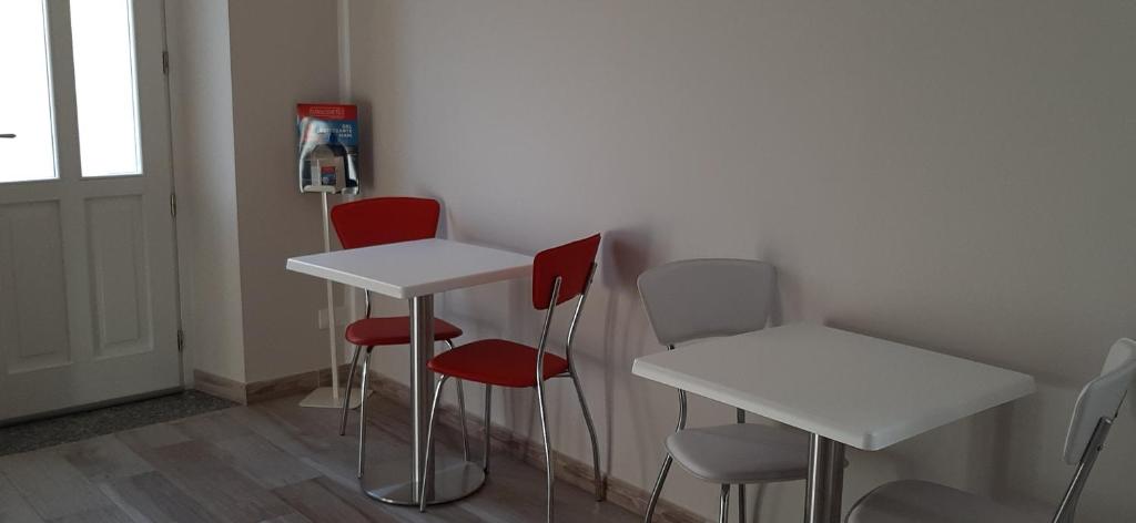 MontescanoLa Casa Colonica的一间设有白色桌子和红色椅子的房间
