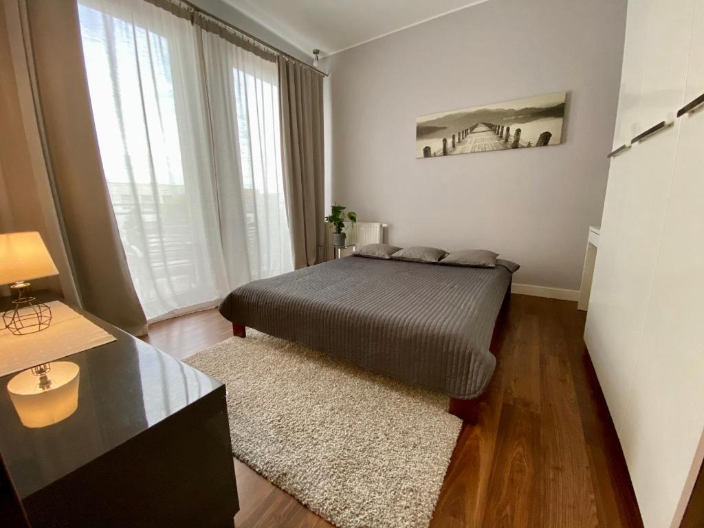 格但斯克Apartament CHANELLKA Garnizon Gdańsk的一间卧室设有一张床和一个大窗户