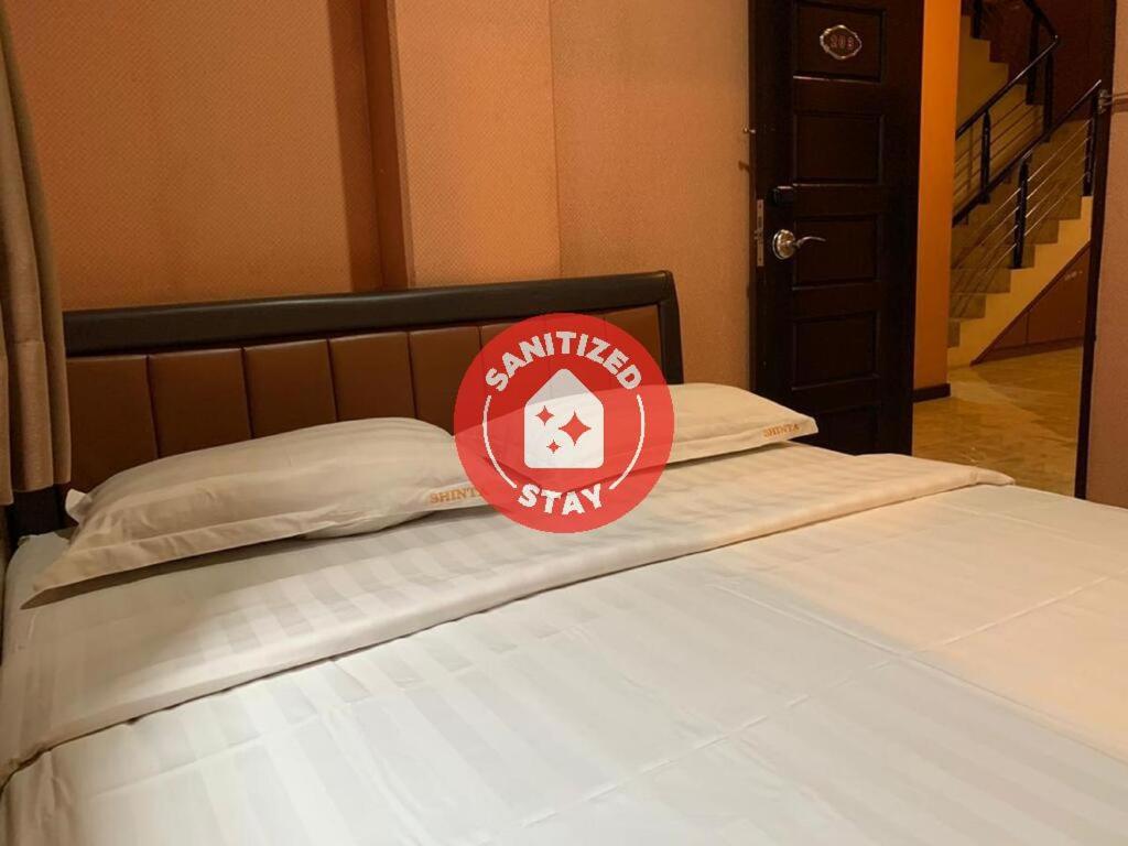 雅加达Hotel Rumah Shinta的上面有红色标志的床