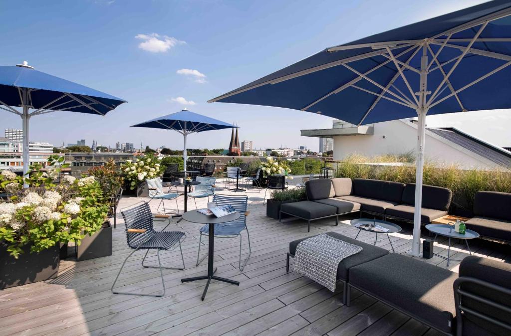汉堡OBERDECK Studio Apartments - Adults only的屋顶上带桌椅和遮阳伞的天井