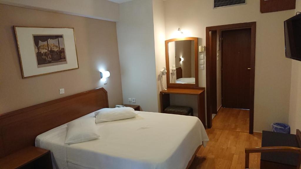 雅典经济酒店的卧室配有白色的床和镜子