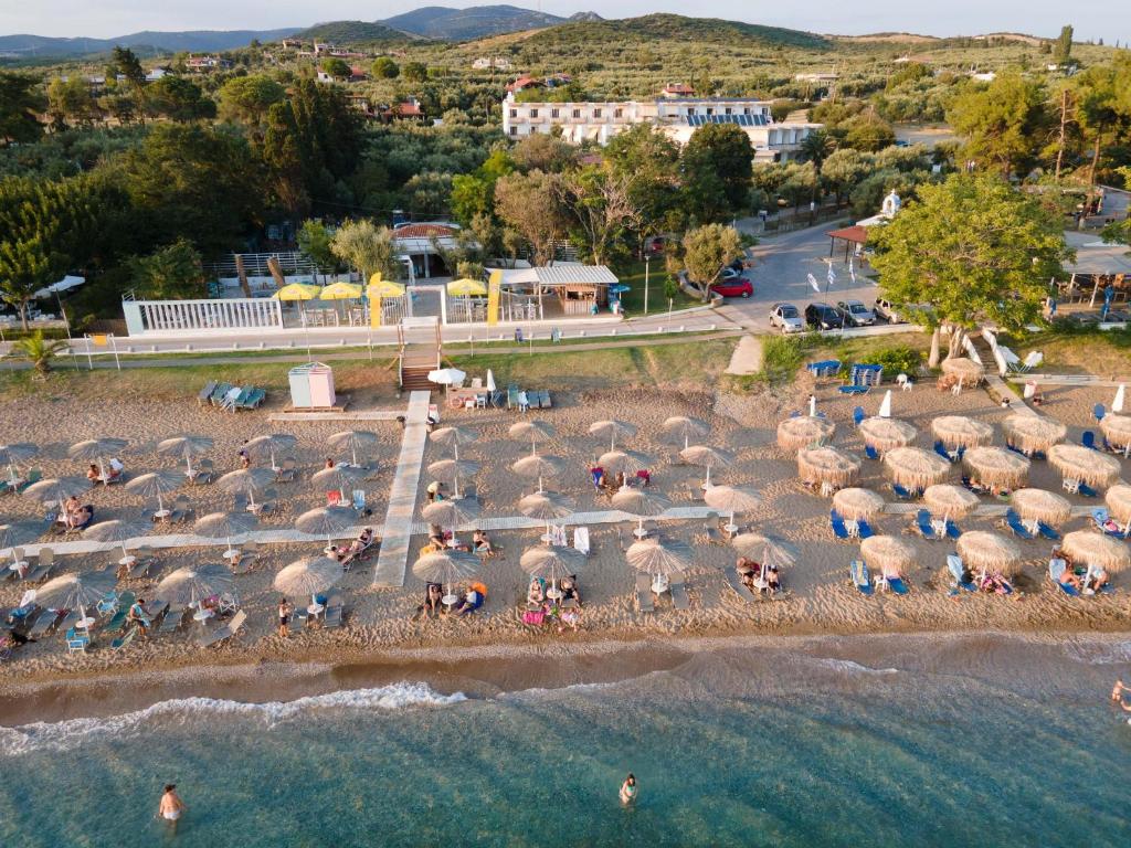 亚历山德鲁波利斯克里奥酒店的一群人在海滩上,带遮阳伞
